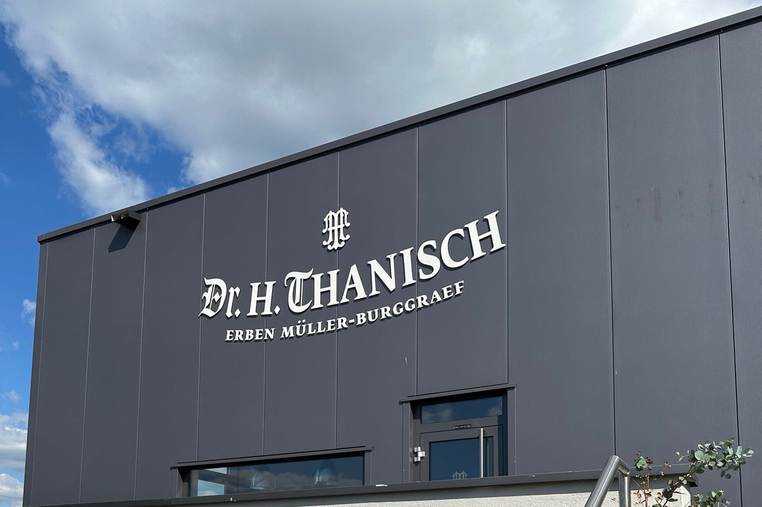 Gebäudewand des Weinguts Dr. H. Thanisch – Erben Müller-Burggraef mit großem Namensschriftzug vor blauem Himmel